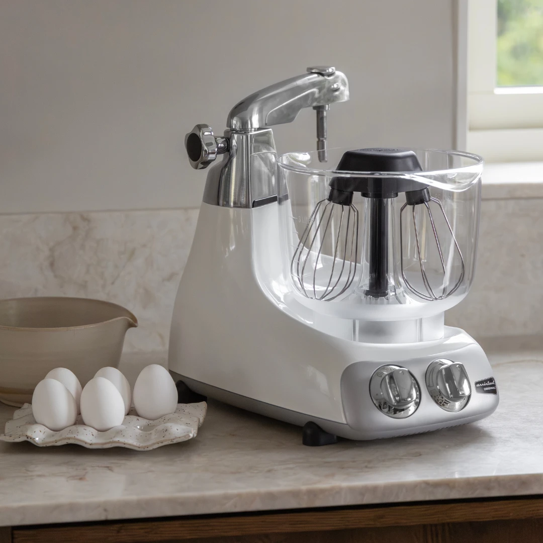 Ankarsrum stand mixer on a kitchen worktop with fresh eggs, the perfect baking mixer machine for professional home baking results.